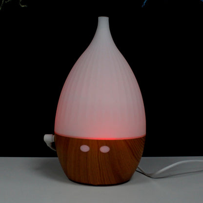 White and wooden diffuser with a red light on a dark background